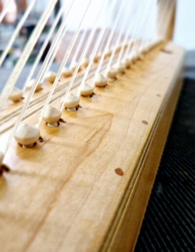 Arpa medieval doble encordado. Caja de sonido tallado en dos piezas de arce. Botones de madera para su encordado exterior.